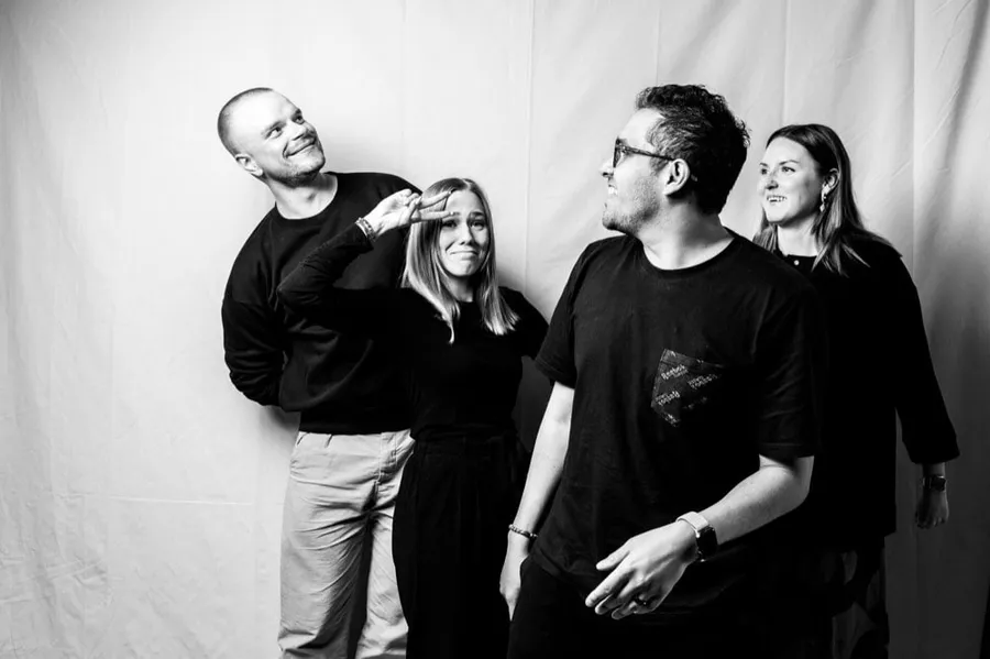 Four members of the Julkee x Lempee team posing playfully in a black-and-white studio photo