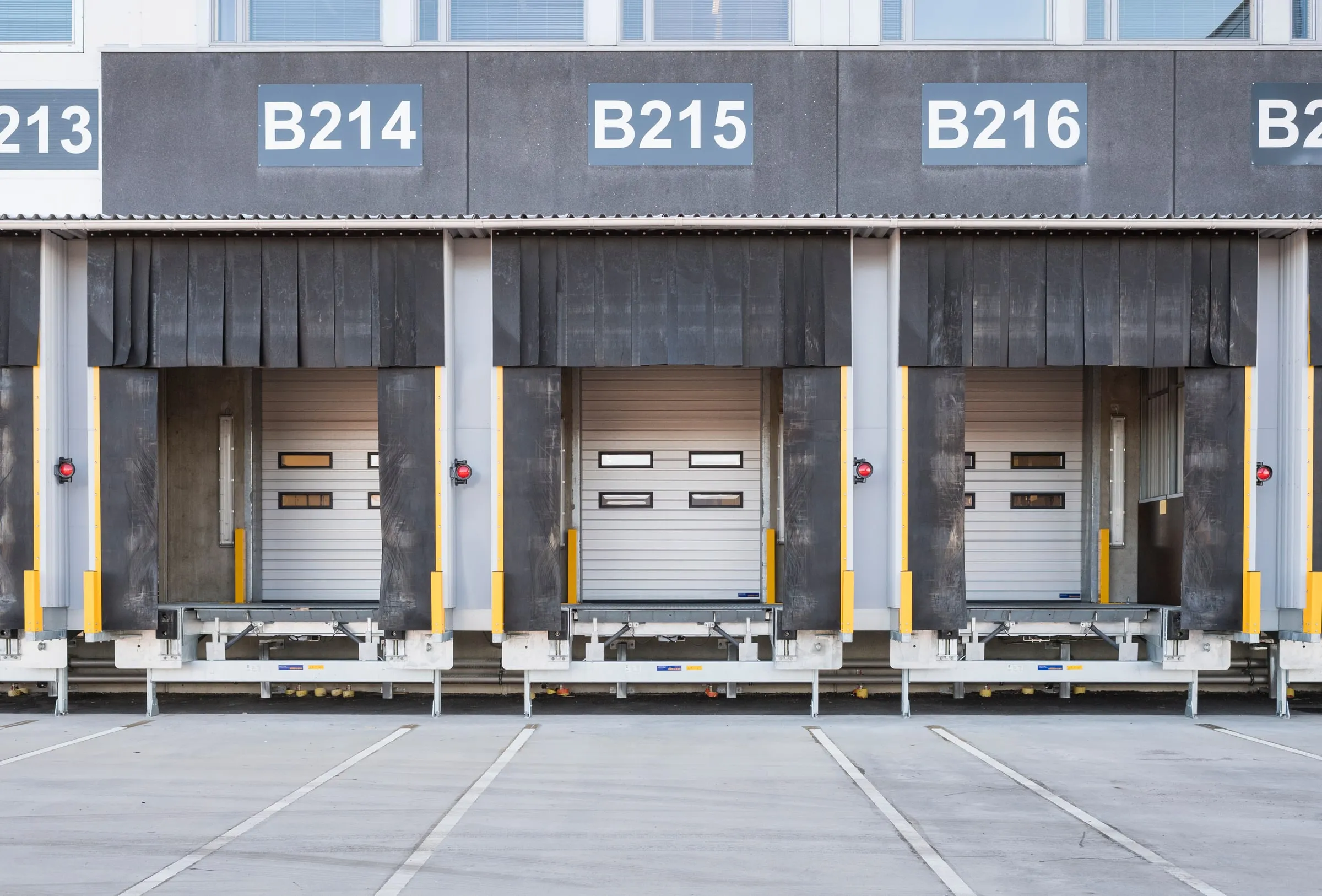 Three loading bays numbered B214, B215 and B216, with Mesvac Hörmann doors and dock levellers in a row