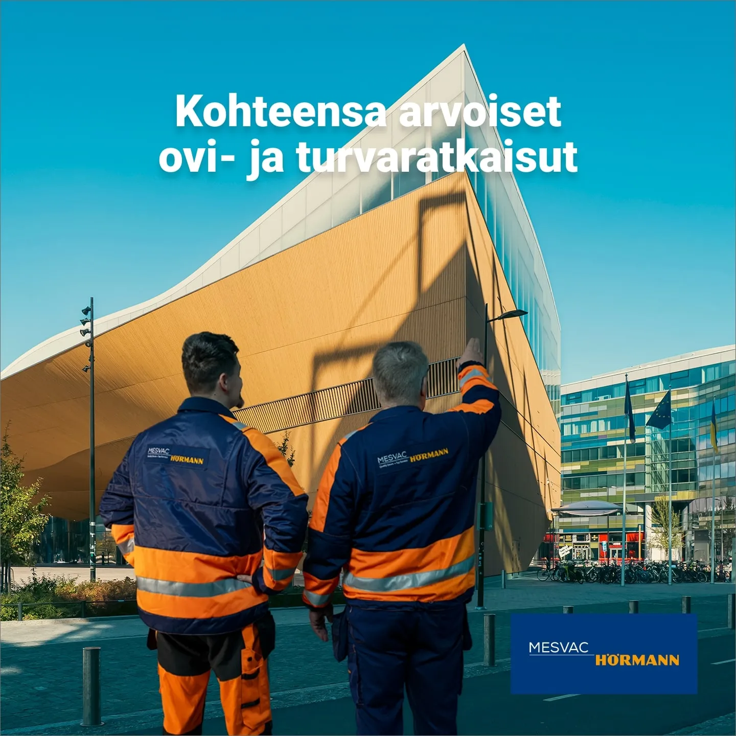 Two Mesvac Hörmann installers seen from behind looking at the wavy wooden facade of the Oodi library, with the ad line Door and safety solutions worthy of their site